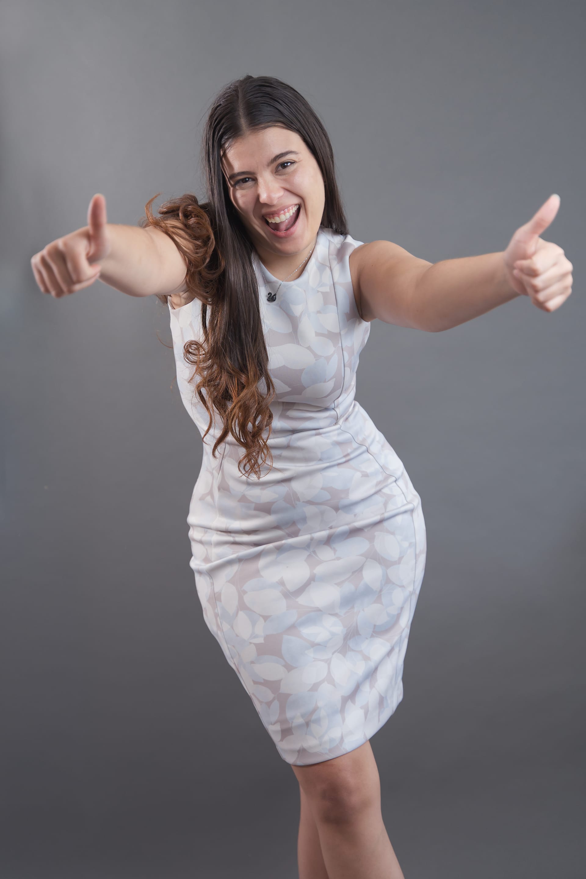 Nicole Castaño sonriendo con los pulgares hacia arriba, en un estudio fotográfico